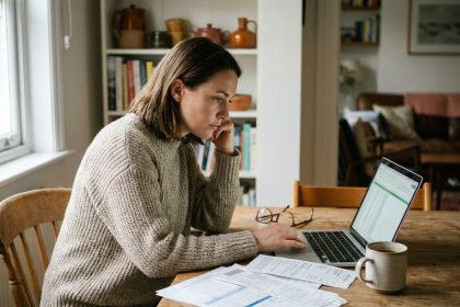 Femme consultant des documents financiers sur un ordinateur portable à la maison pour trouver de l'argent rapidement en toute sécurité